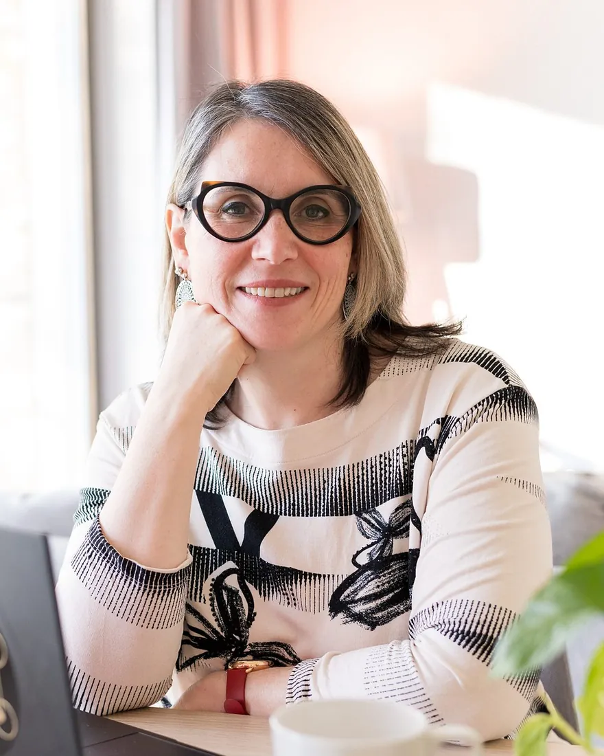 Communicatrice animalière : Sophie Bordes-Meunier sourit à son bureau, le menton dans la main, devant son ordinateur portable