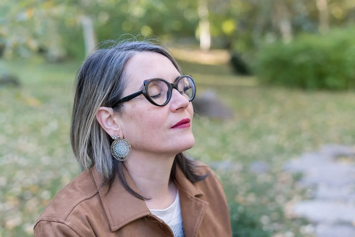 Communicatrice animalière : Sophie, les yeux fermés, profite d’un moment de calme dans un jardin d’automne