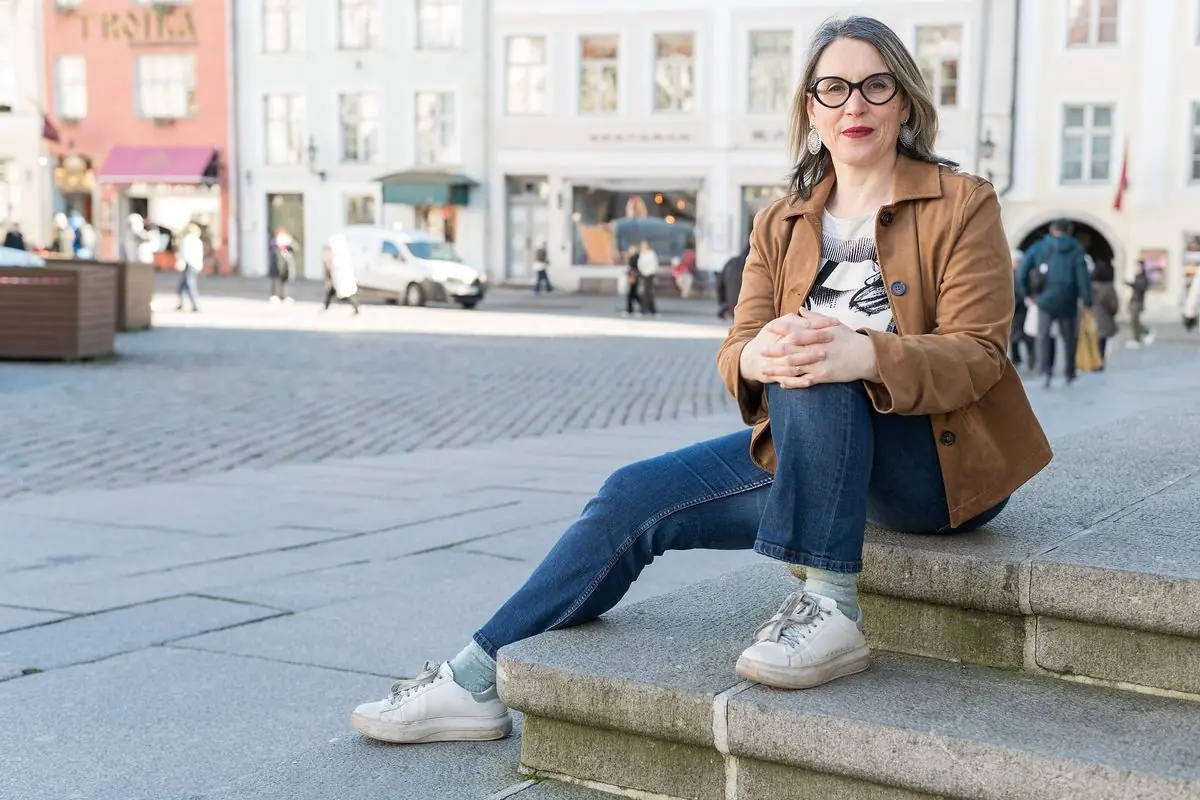 Formations en ligne : Sophie Bordes-Meunier assise sur des marches, dans la vieille ville de Tallinn