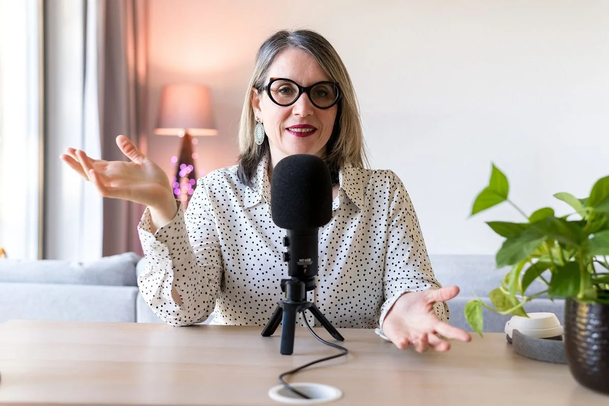Formations en ligne : Sophie explique, les mains ouvertes, devant un micro