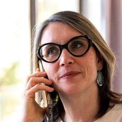 Soin énergétique à distance : Sophie au téléphone, assise dans son salon