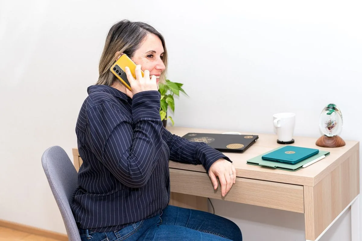 Tarif communication animale : Sophie au téléphone, assise à son bureau